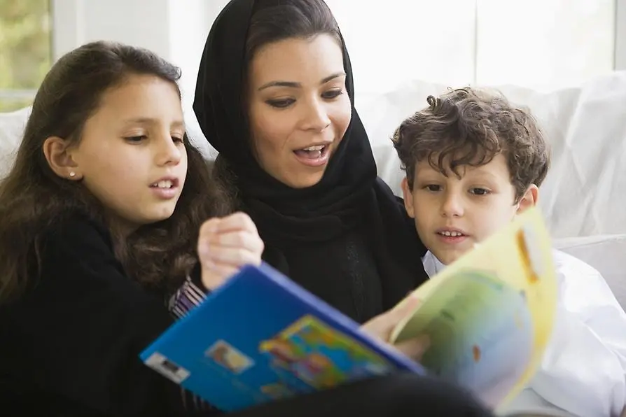 En kvinna läser för 2 barn.