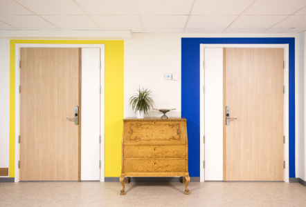 två dörrar i ett äldreboende en med gul färg och en med blå.